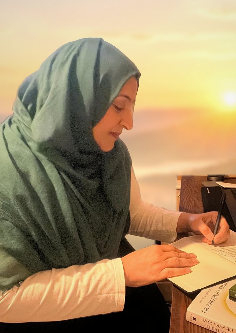 Jasmine Ali writing notes at her desk